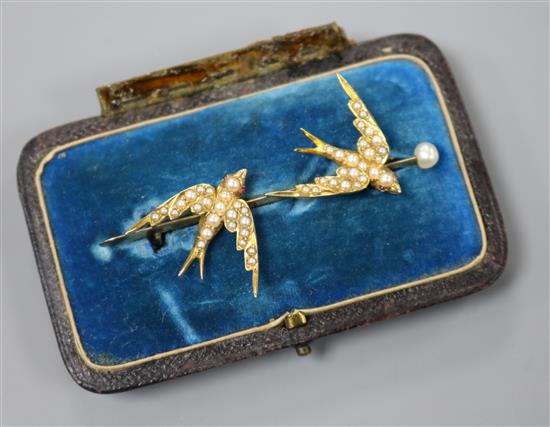 A Victorian gold and pearl bar brooch set with two swallows in flight, inscribed 8th June 1886, 55mm.